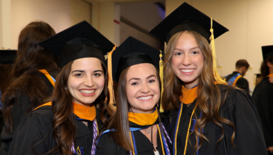 three students smiling the suburban showplace, waiting to walk out and be seated